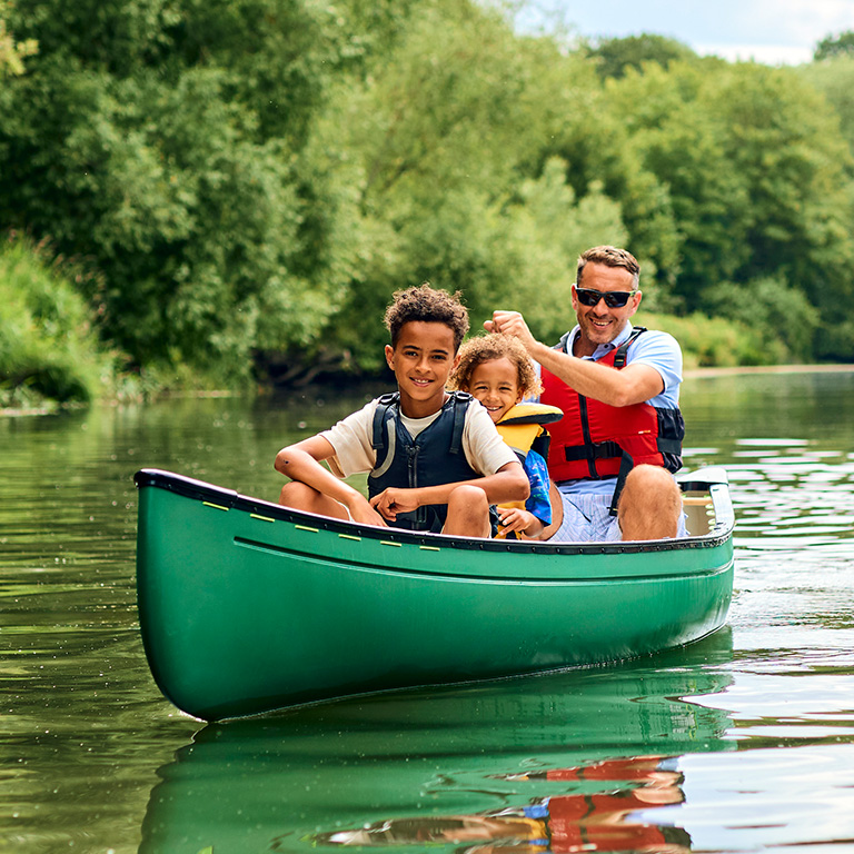 Vader en twee zonen in een groene kano